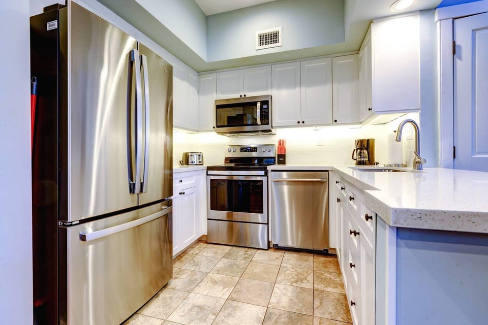 The kitchen features updated stainless steel appliances and sleek quartz countertops, combining style and functionality for effortless meal prep.
