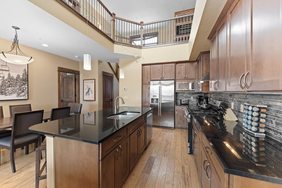 Luxury kitchen with stainless steel appliances and breakfast bar seating.