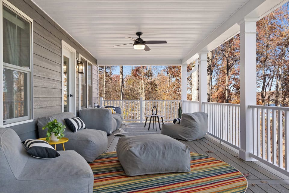 Covered Deck - Plush lounge seating, colorful pillows, and ceiling fans make this wraparound porch a favorite spot to unwind.