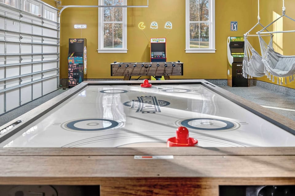 Game Room - Air hockey, foosball, arcade cabinets, and a hanging hammock chair turn the garage level into an all-ages entertainment zone.