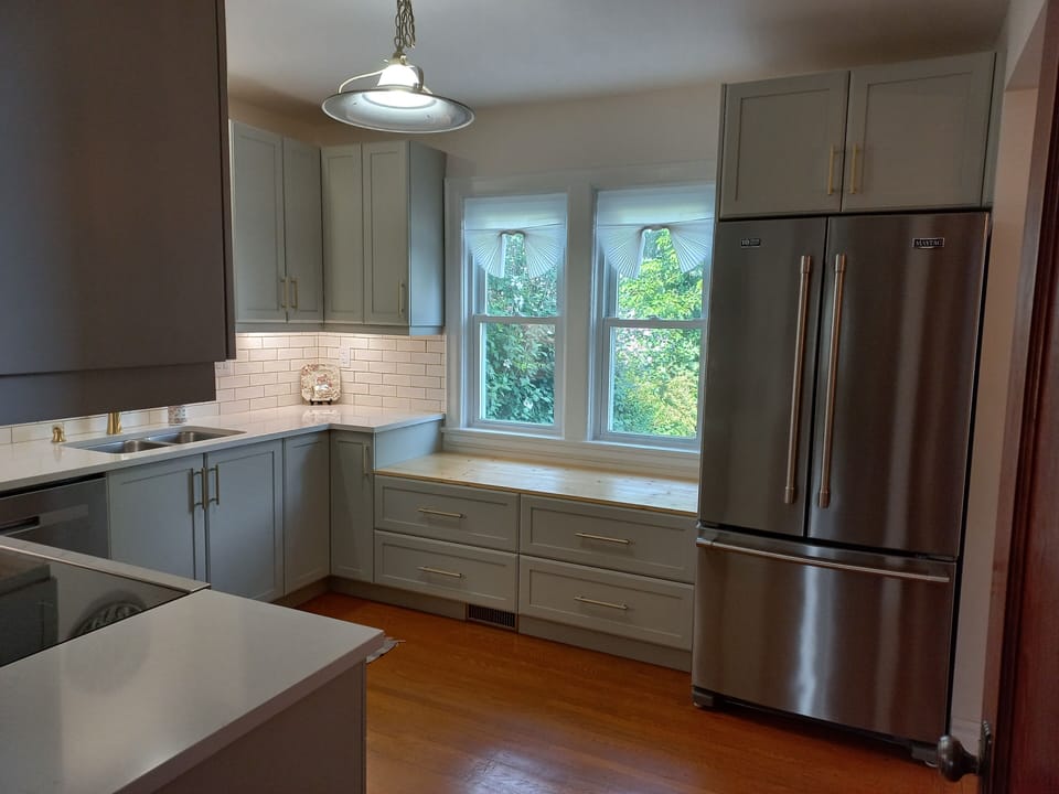 Kitchen with storage drawers and stainless fridge with water dispenser
