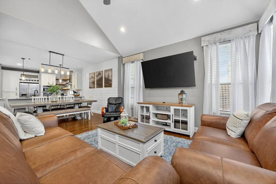 Bright, open living space with cozy leather seating, a 75` smart TV, and a spacious dining area. Perfect for families and groups to relax, cook, and gather in comfort.