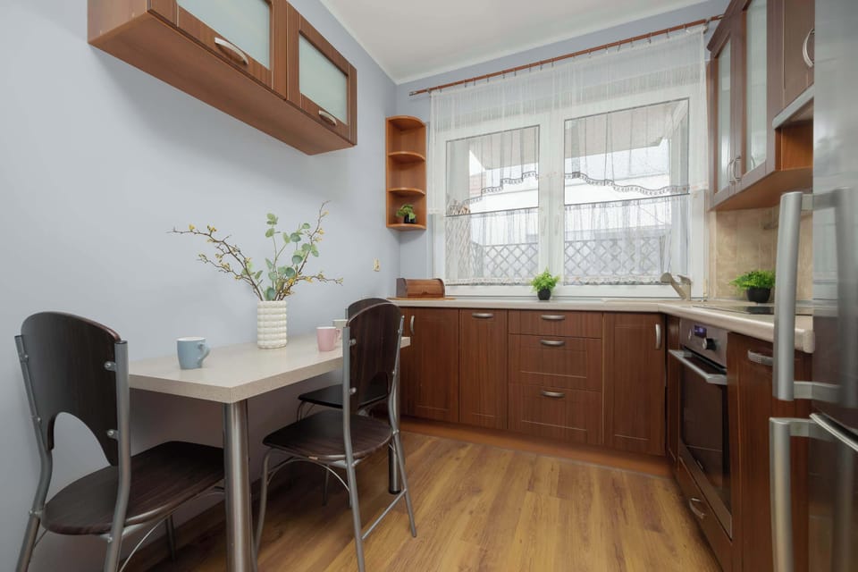 Stylish kitchen finished in warm wood tones with sleek stainless-steel appliances.