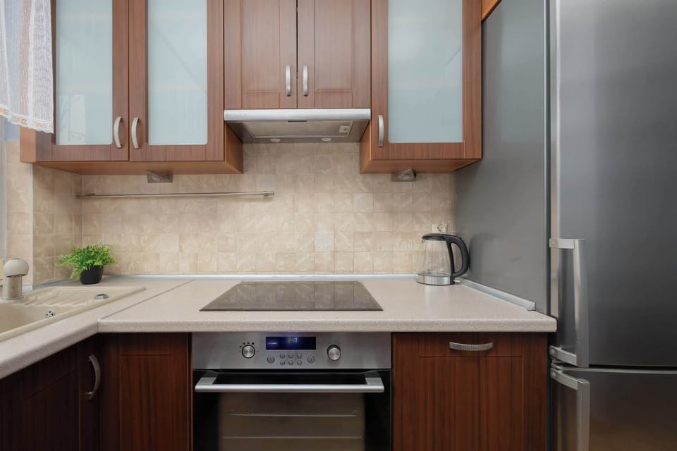 Contemporary kitchen with wooden cabinets, stone backsplash and modern appliances.