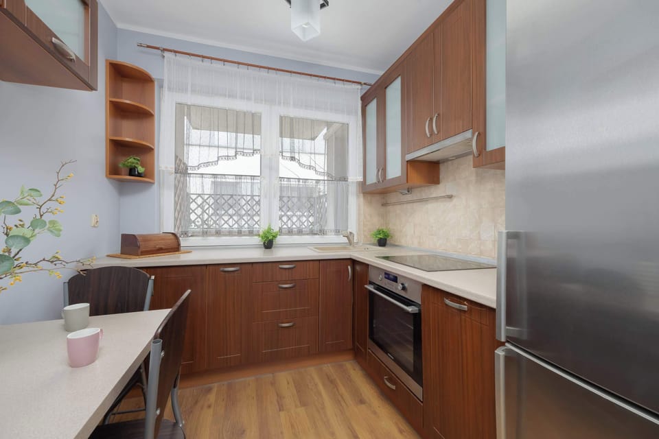 Contemporary kitchen with wooden cabinets, stone backsplash and modern appliances.