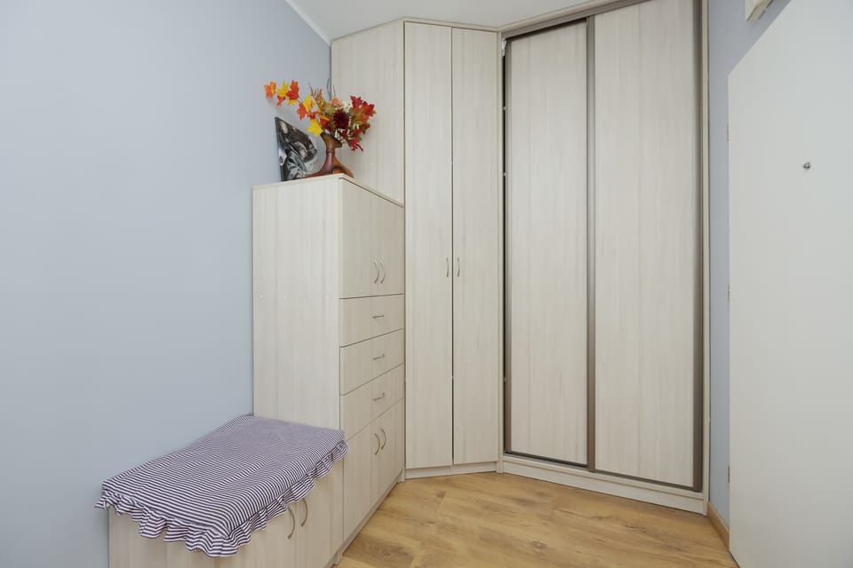 Charming hallway corner with a white dresser, built-in wardrobe and soft decorative touches.