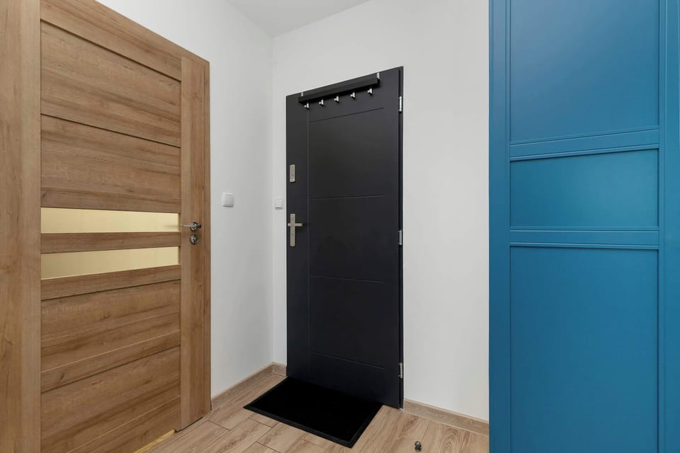 The bright hallway with wooden accents welcomes guests with warmth and guides them smoothly into the rest of the home.