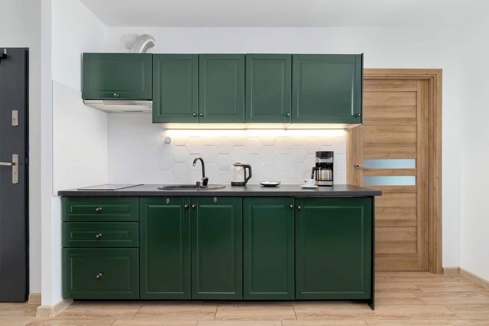 The spacious deep-green kitchenette provides all the functionality needed to comfortably prepare everyday meals.