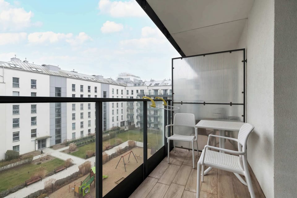 The balcony with a comfortable chair offers a peaceful spot for morning coffee while enjoying the view of the courtyard.