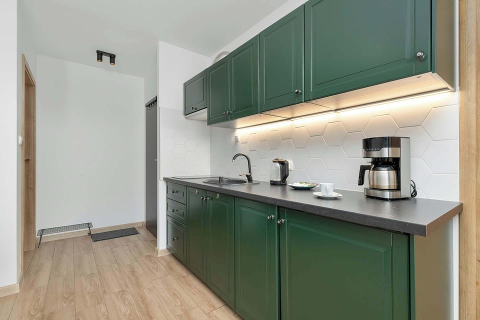 The thoughtfully designed deep-green kitchen offers the comfort of preparing home-style meals during your stay.
