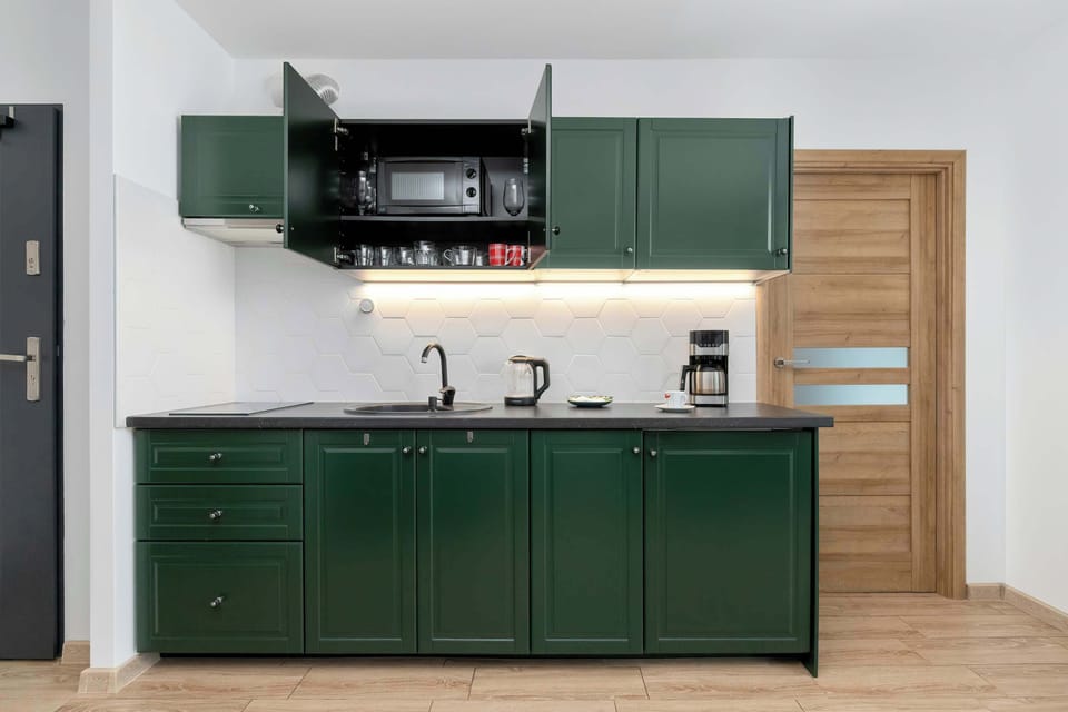 The open cupboard with dishes ensures easy access to essentials, making meal preparation smoother throughout your stay.
