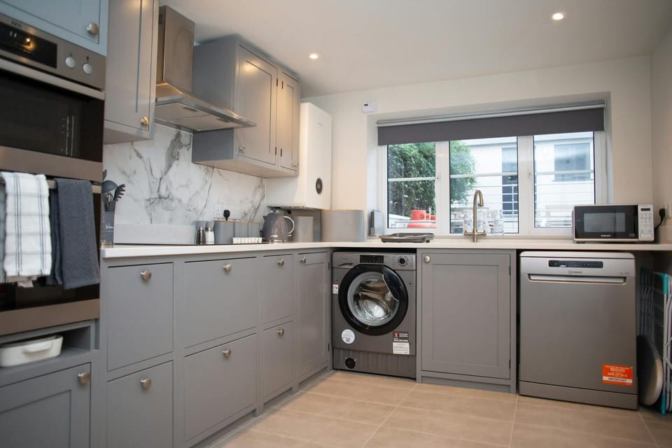 Kichen with electric oven, microwave, washing machine, hob, toaster, window