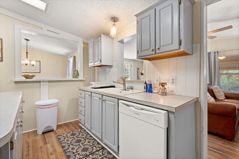 This open kitchen feels spacious and connected, thanks to a large pass-through window and functional layout that supports long-term living.