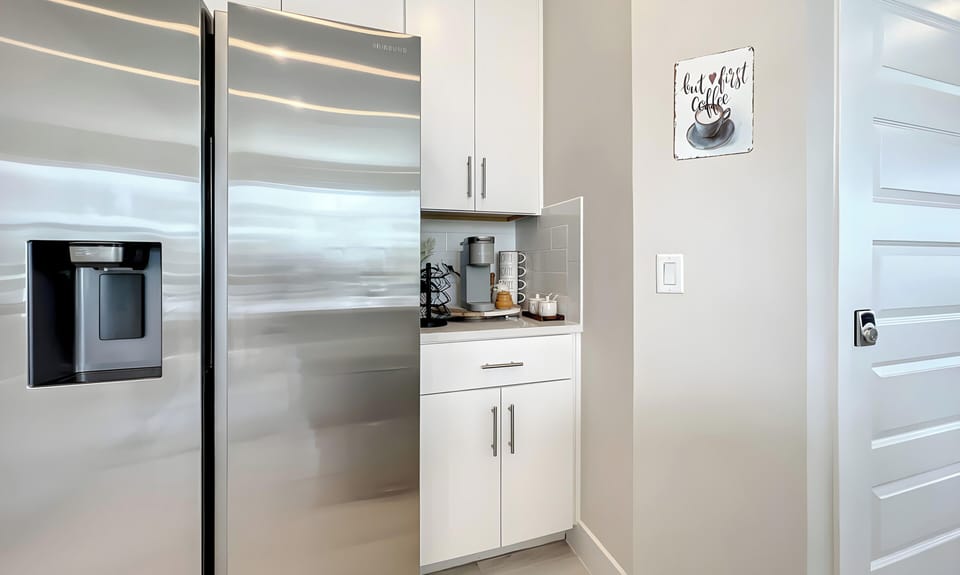 Experience a stylish kitchen with polished stainless steel appliances and sleek white cabinetry that maximize both space and style. The bright, open atmosphere invites you to prepare meals in a beautifully flowing layout.