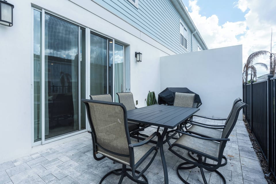Step outside to a private patio with a spacious dining table, comfortable seating, and a barbecue grill, offering a convenient setting for outdoor meals and relaxing moments during your stay.