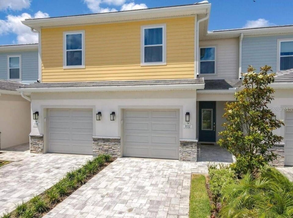 Welcome to this charming vacation home with a vibrant yellow façade. The beautifully paved walkway, surrounded by lush greenery, invites you to explore the welcoming entrance, beautifully enhanced by stylish outdoor lighting.