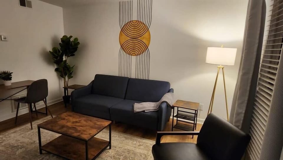 Living Room: Welcome to our roomy living room, furnished with a cozy love seat, a mini side table, an accent chair, and a coffee table.