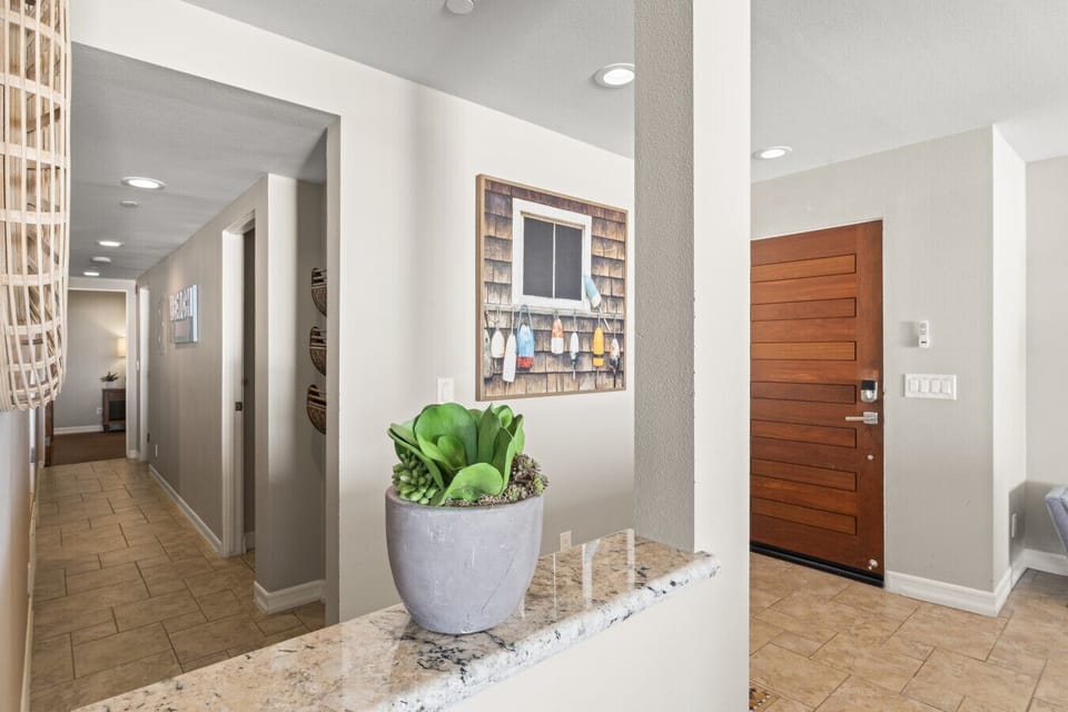 Bright entry hallway with coastal décor and easy access to bedrooms and living areas.