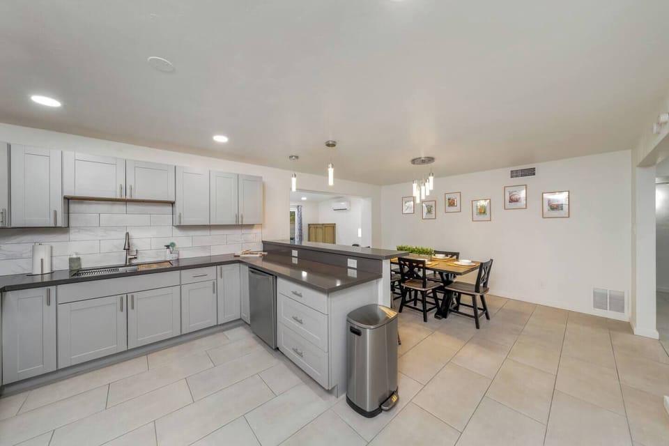 View of the well-equipped, fully stocked kitchen and dining area with lovely table that comfortably seats six