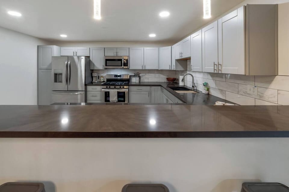 Well-equipped and fully stocked kitchen with plenty of storage, stainless steel appliances, lots of counter space, and peninsula providing additional seating