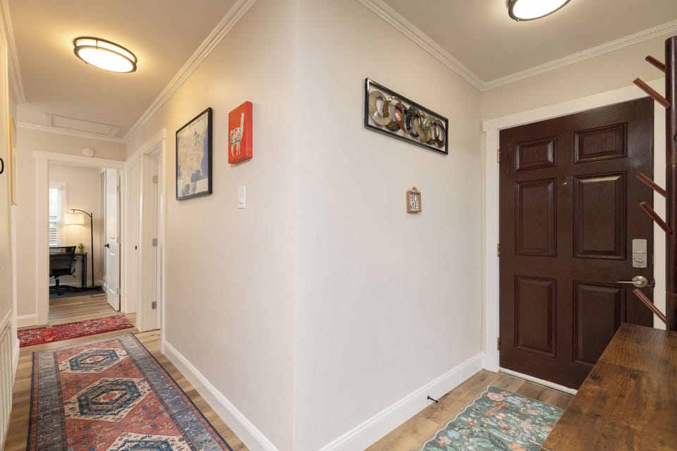 Private front entrance opens into a bright hallway with stylish rugs and décor