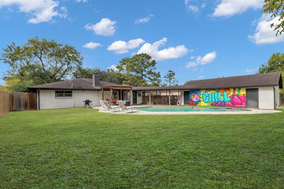 Dive into fun in a vibrant backyard with a sparkling pool and lively mural!
