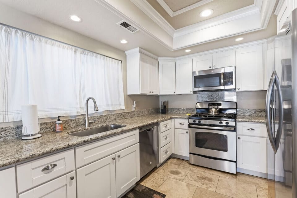 Fully stocked kitchen with granite counters, gas range, and all cooking essentials.