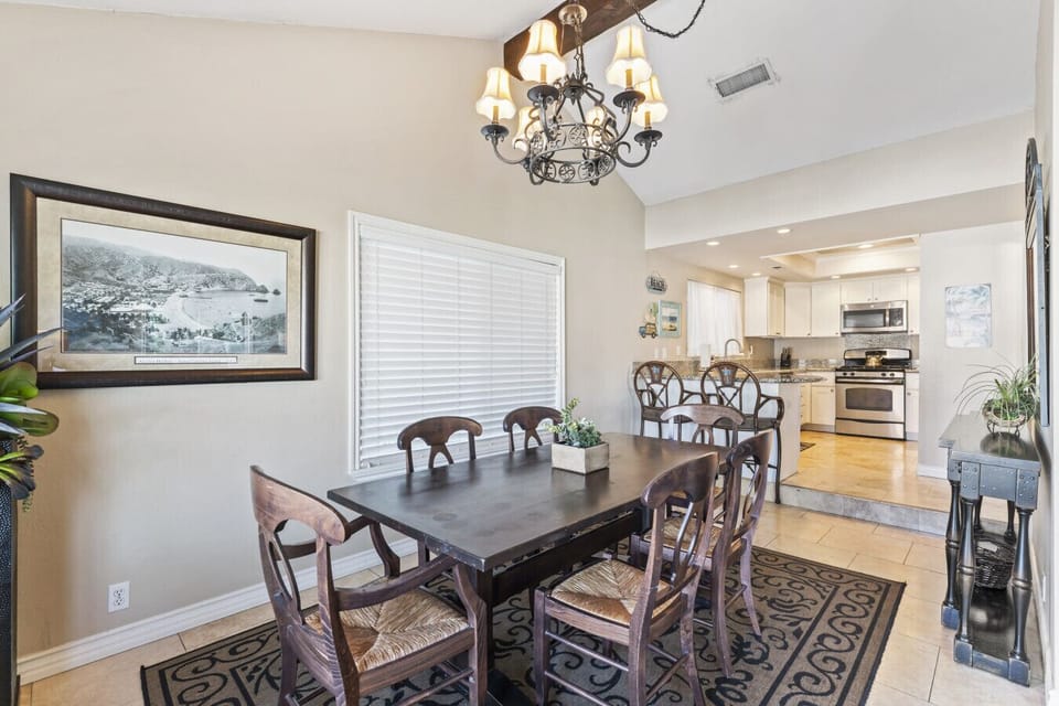 Spacious dining area with seating for six, flowing into the fully stocked kitchen.
