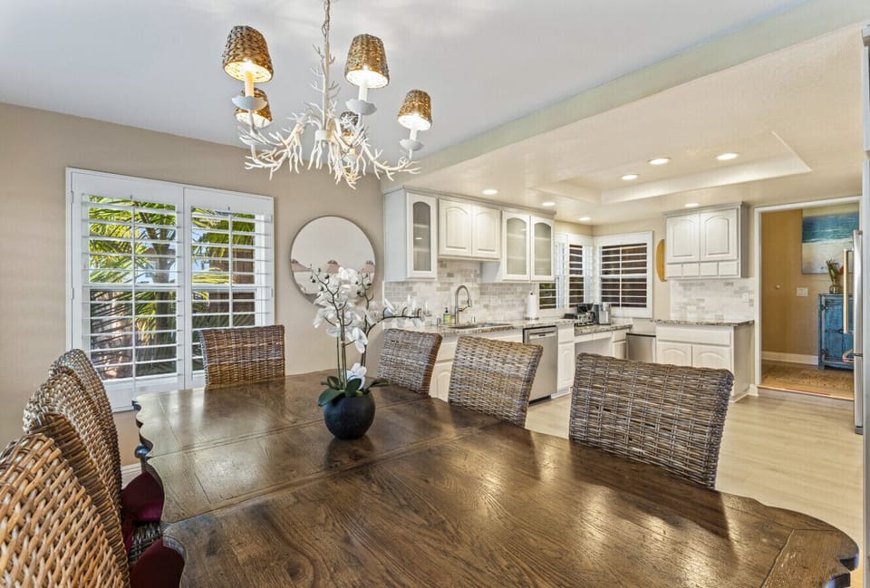 Open dining area w/ chandelier, large table & seamless flow into the kitchen