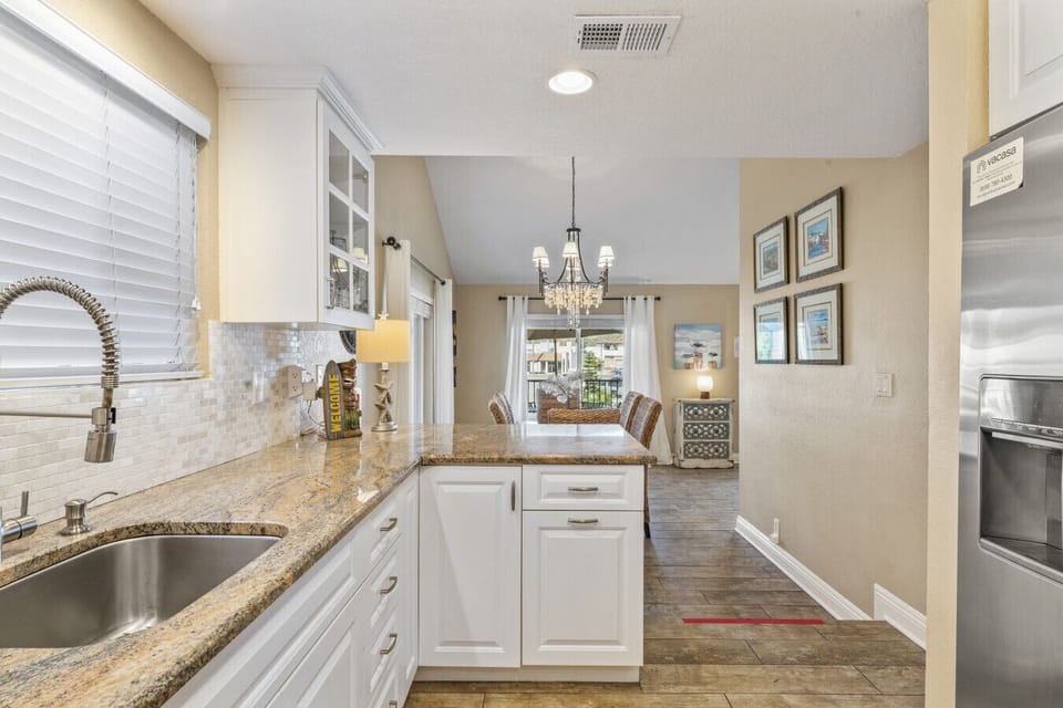 Bright kitchen w/ granite counters, stainless appliances & open flow to dining area