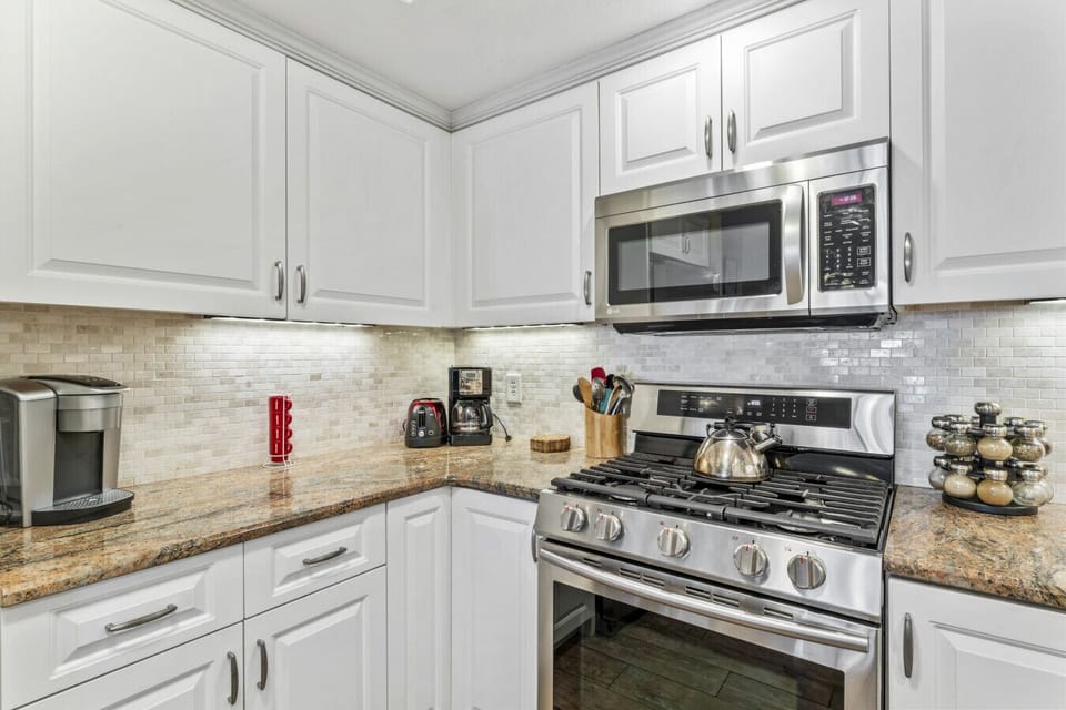 Bright kitchen w/ modern appliances, tiled backsplash & ample counter space