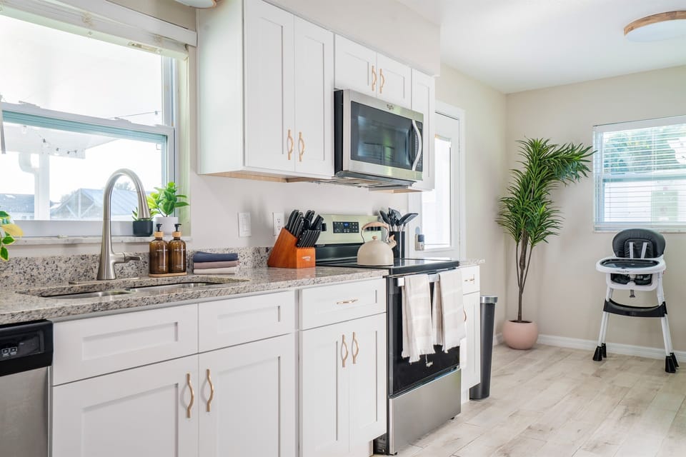 Fully stocked kitchen with granite counters and stainless appliances.