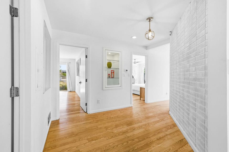 A bright, clean hallway connects the main living areas to Bedroom 1 and Bedroom 2.