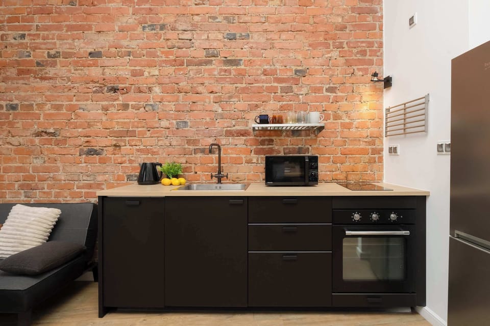 Modern kitchen with brick wall and built-in appliances.