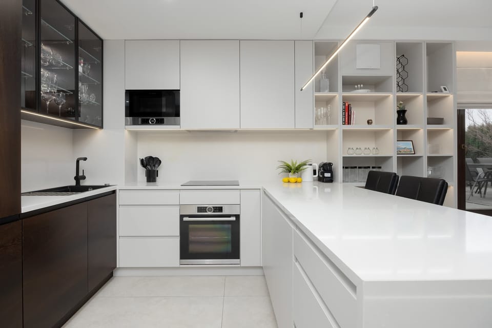 Bright kitchenette with white cabinetry and modern appliances.