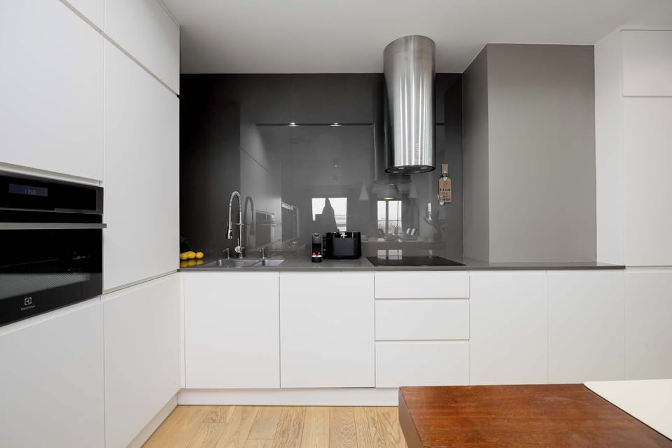The modern black-and-white kitchen offers effortless meal preparation, with a functional layout that makes everyday cooking smooth and enjoyable.