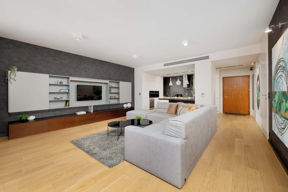 The living room with a large TV and soft sofa creates an inviting setting for downtime, allowing guests to unwind in a warm, contemporary ambiance.