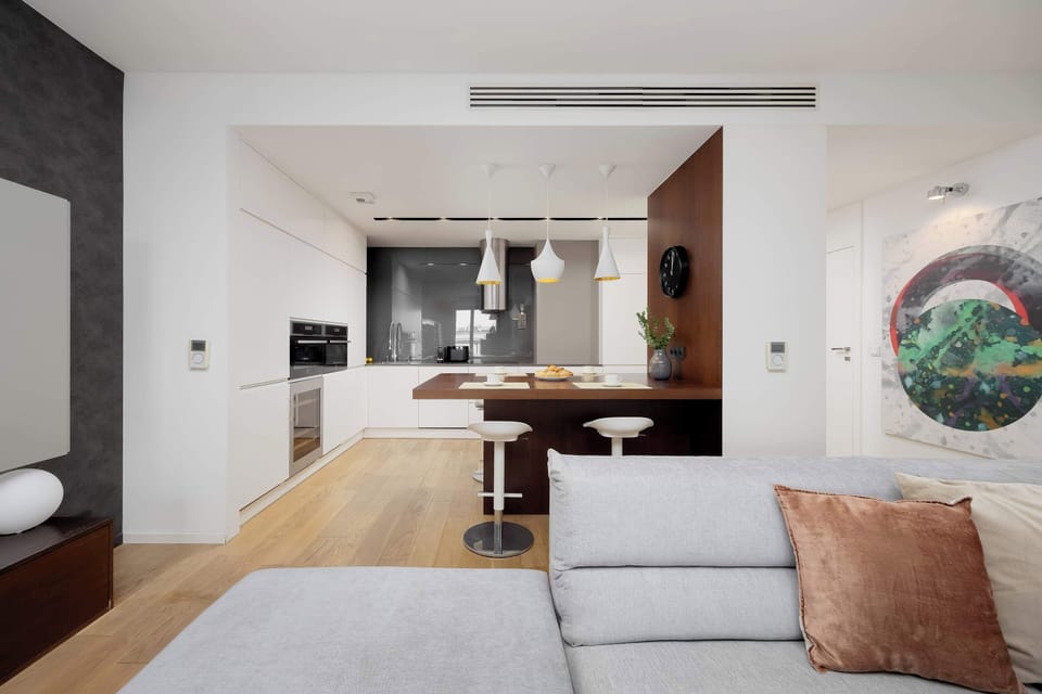 The open layout connecting the lounge and dining space enhances the sense of spaciousness, giving guests the freedom to move easily and enjoy the bright, harmonious design.