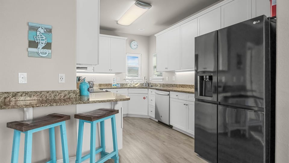 Dune Our Thing - Kitchen with a breakfast bar and full-sized fridge with ice maker for added convenience.