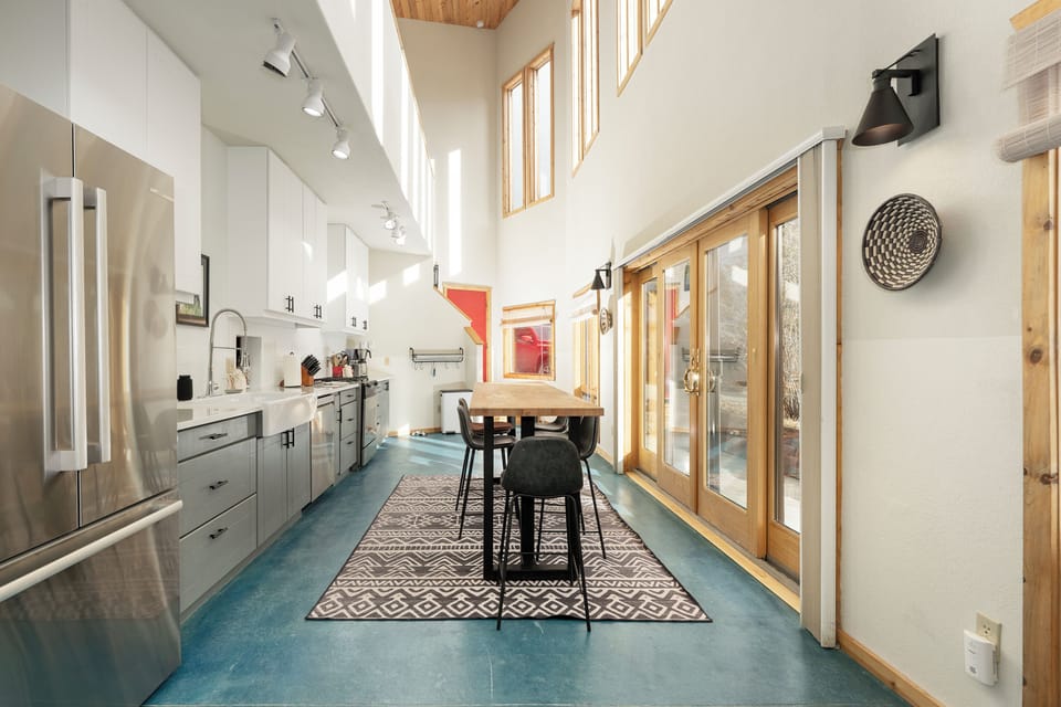 Your modern kitchen flows seamlessly with natural light streaming through soaring windows, creating an inspiring space for cooking and gathering.