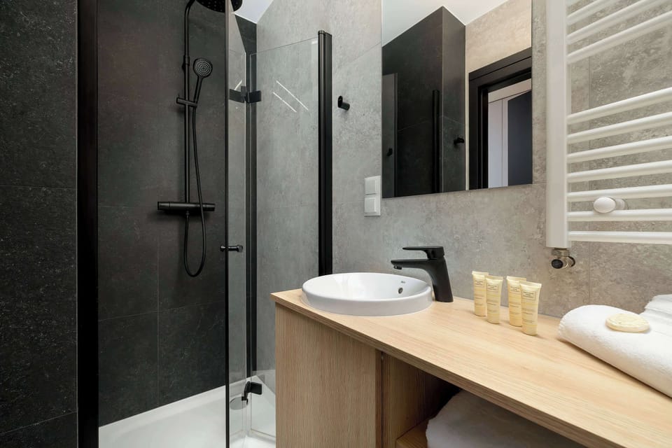 The bathroom's contemporary design includes fresh towels and a hairdryer.