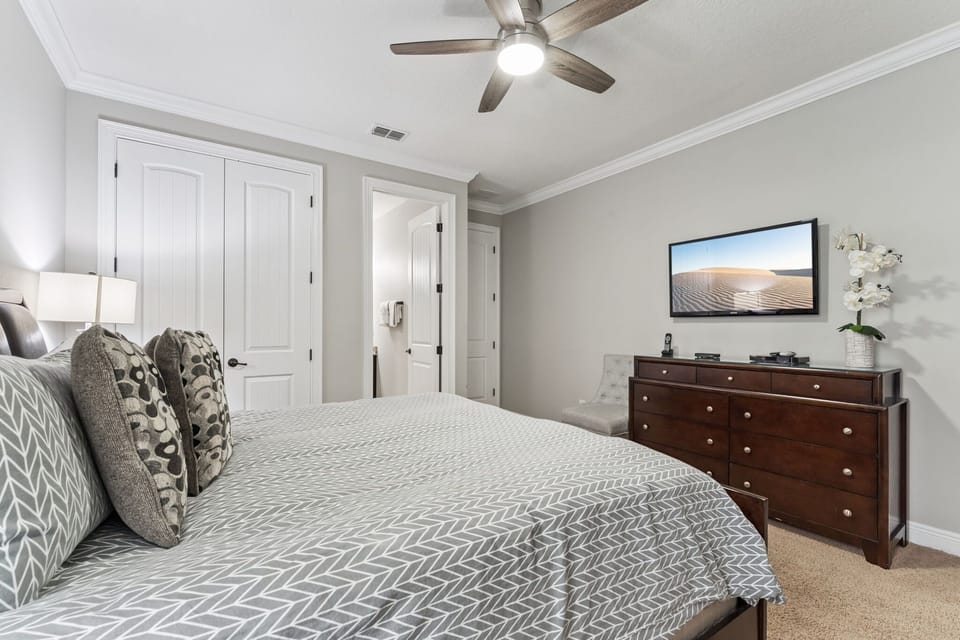Spacious retreat featuring a king bed, crisp white décor, and entertainment-ready TV.