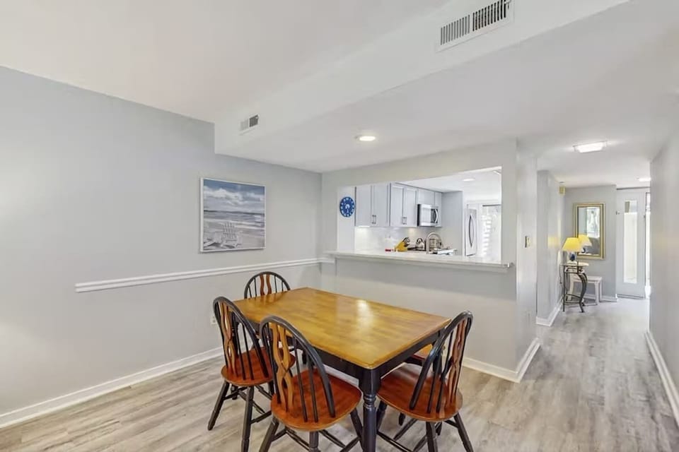 Dining area with wooden table and open kitchen layout in a modern setting