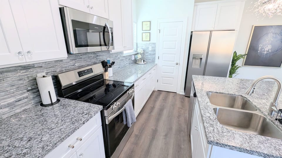 This gorgeous, new kitchen is ready to serve up a delicious meal with stainless stove/oven, microwave, dishwasher, and fridge. 