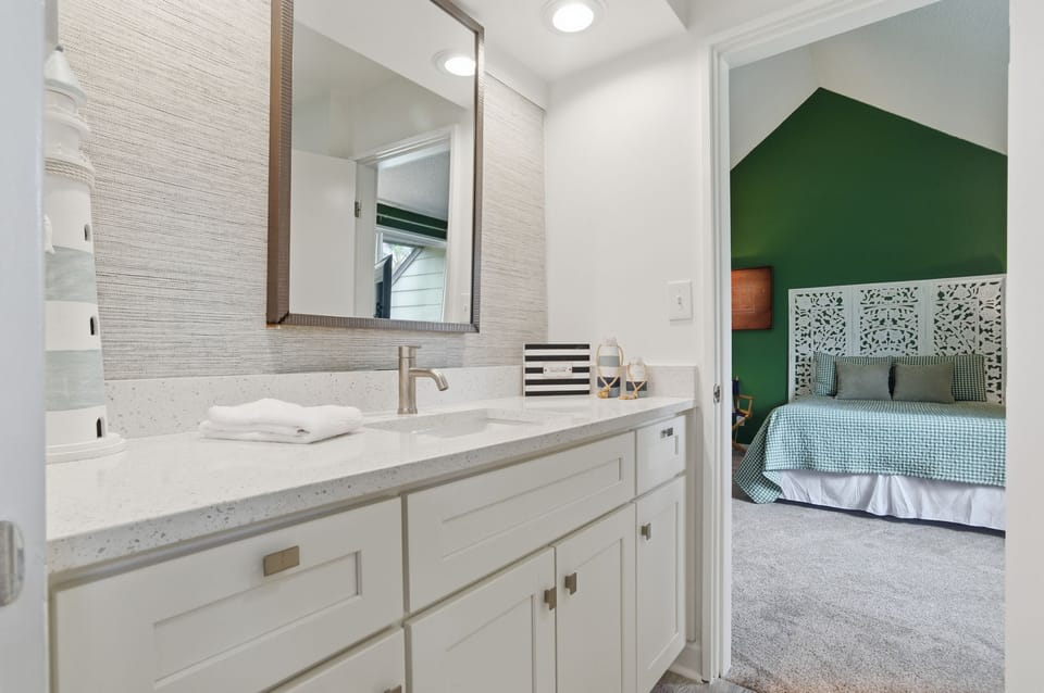 Unwind in this bathroom with spacious vanity, perfect lighting, and thoughtful coastal touches that make getting ready a pleasure.