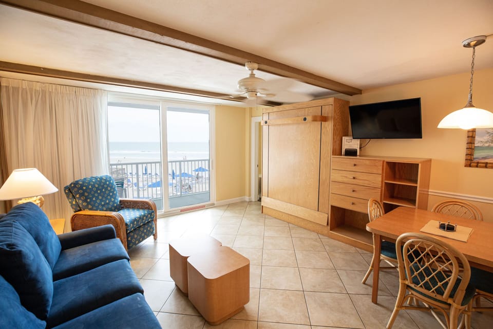 The inviting living area showcases a blend of comfort and style with ocean views visible through the sliding glass doors.