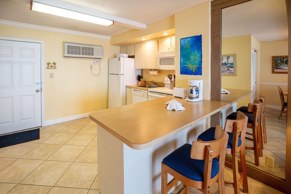 An inviting breakfast bar with seating connects the kitchen to the living area, enhancing the open layout of the condo.