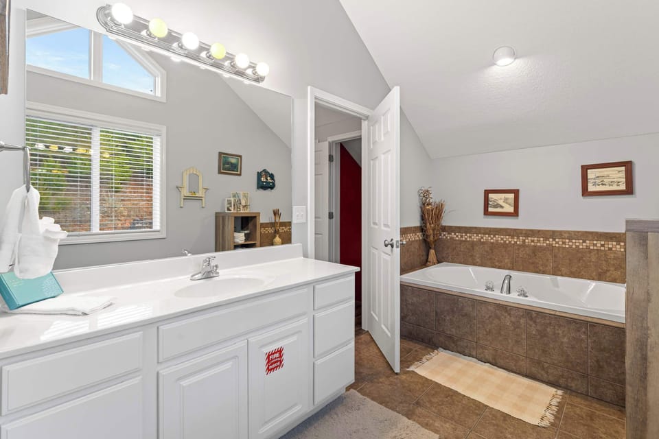Elegant space with granite accents, soaking tub, and natural light streaming in!