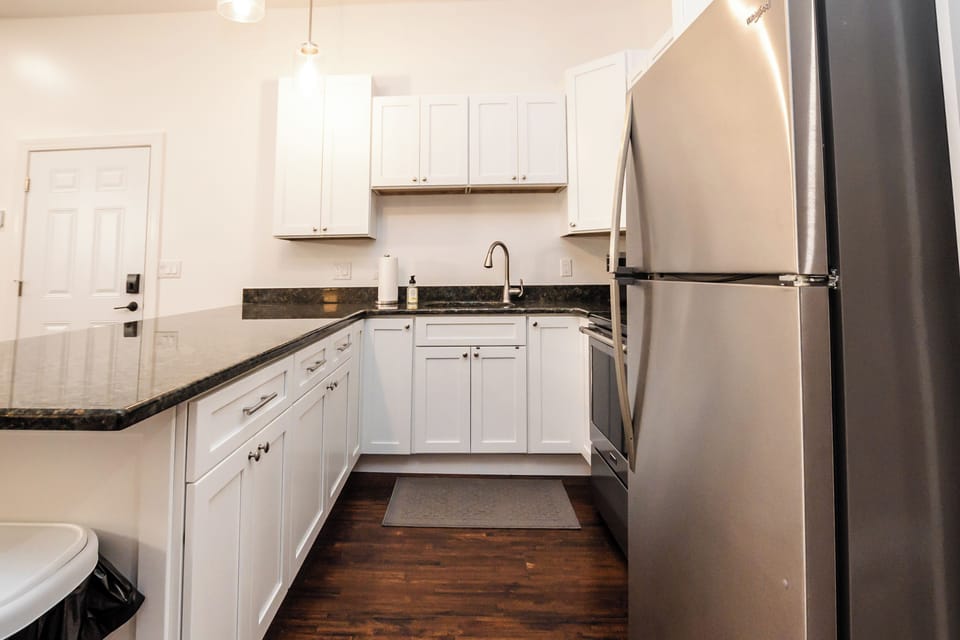 Bright, fully stocked kitchen with stainless appliances and granite counters
