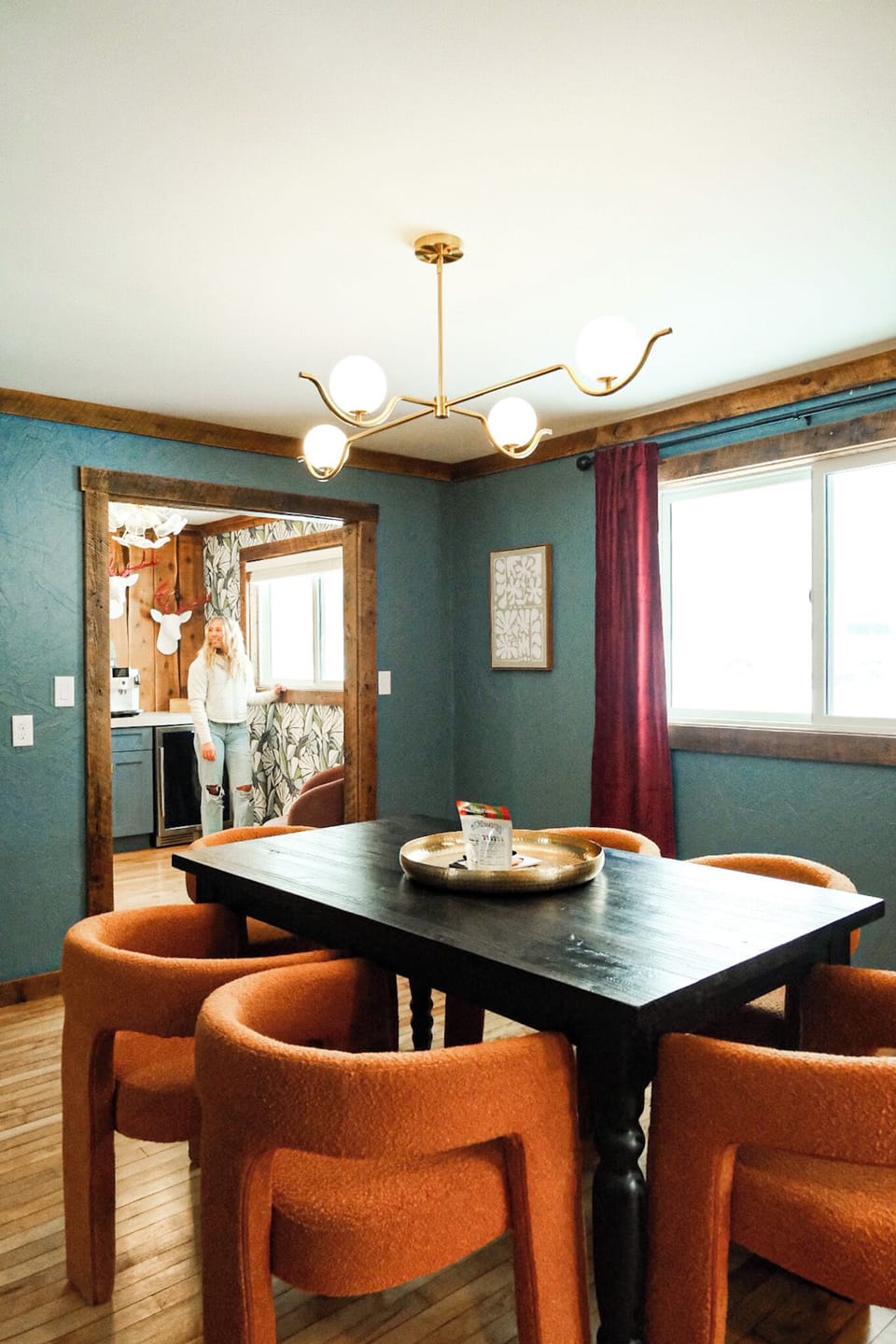 Warm, stylish dining room with bold colors, plush seating, and natural light